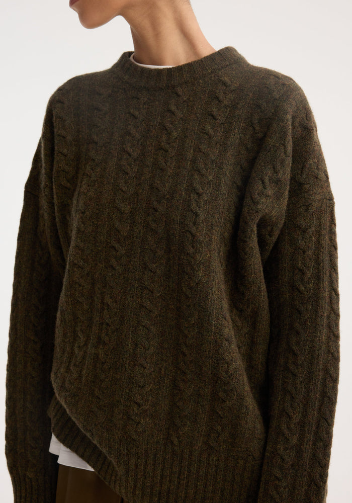 Cable knit jumper in forest melange, showcasing an oversized fit with drop shoulders, round neckline, and classic cable pattern in soft, textured wool.
