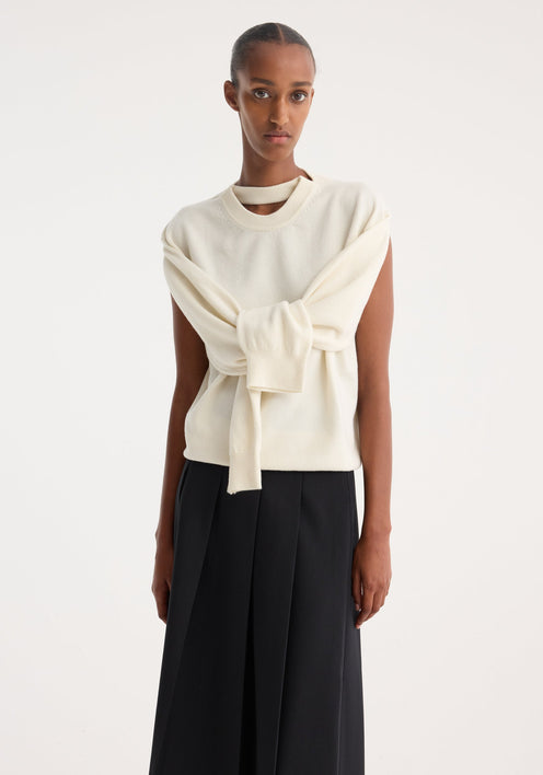 Model in minimalist attire showcasing a Crewneck with open neck | off white, featuring draped sleeves and a key-hole detail, paired with a black midi skirt.