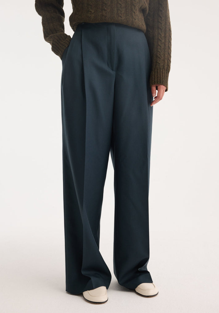 Mid-waist tailored trousers | storm, featuring high-waisted, wide-leg design in soft virgin wool with a tailored waistband and double pleats, styled with a tucked-in sweater.