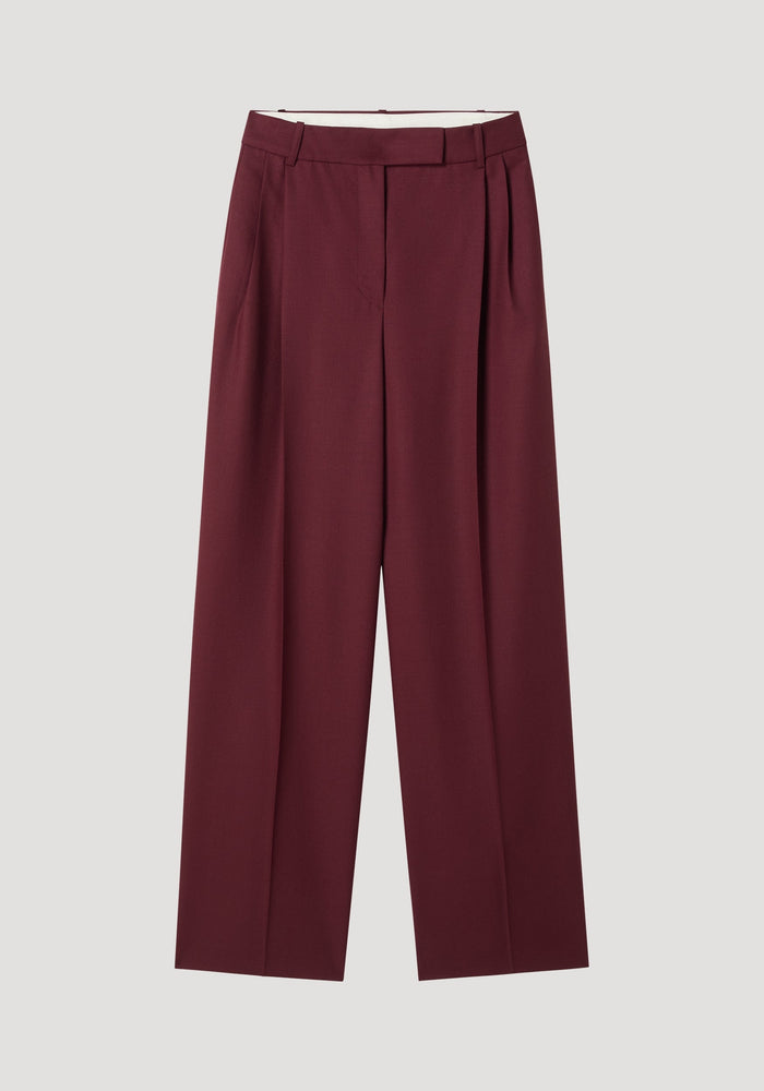 Mid-waist tailored trousers in burgundy, featuring a straight-leg cut with belt loops, a concealed front closure, and subtle pleats, made from 100% virgin wool.