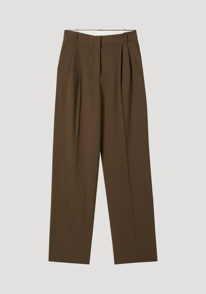 Signature tailored trousers in forest, featuring high-waisted cut, front pleats, wide legs, tailored waistband, and hidden closure, crafted from 100% virgin wool.