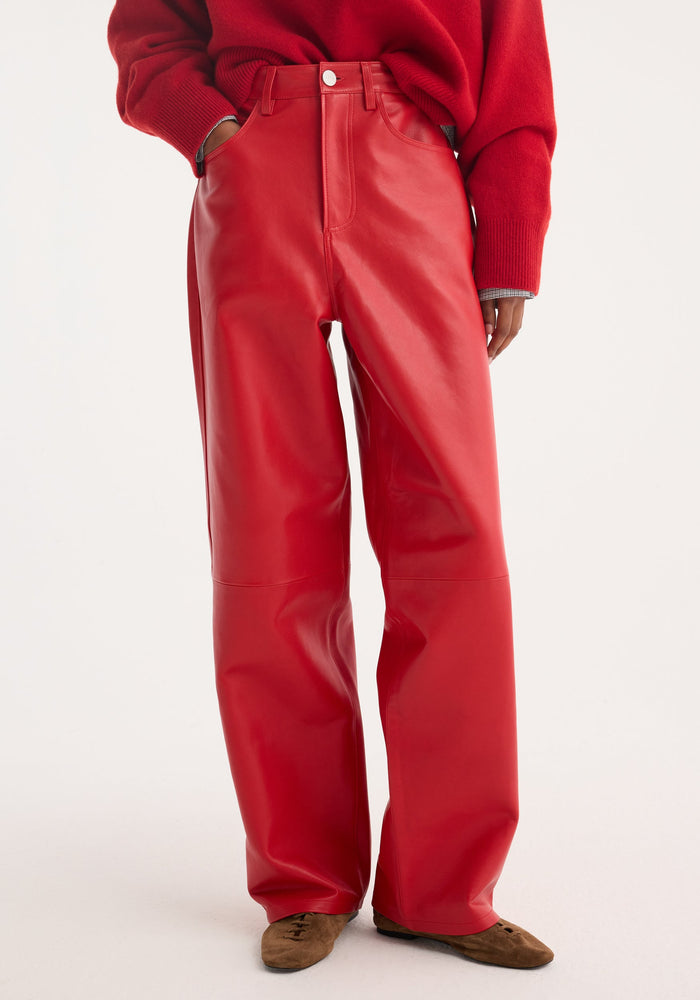 Baggy leather trousers | rosso: High-waisted, wide-leg red leather trousers with a relaxed fit, paired with a chunky knit sweater and brown suede flats.