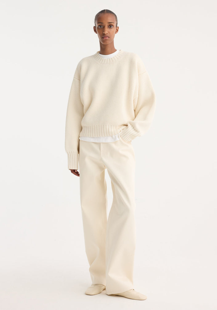 Compact cotton trousers in off-white, featuring a wide-leg, low-waist design. Includes button and zip closure, side pockets, and belt loops for a minimalist look.