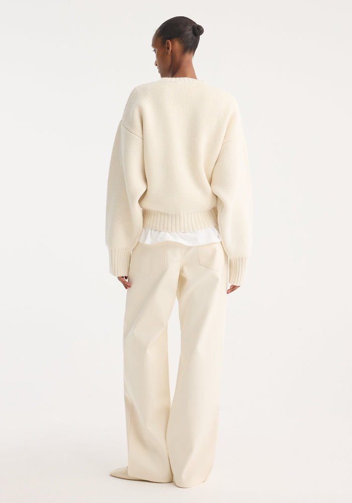 Person wearing Compact cotton trousers | off white, featuring wide-leg fit, low waist, crafted from Italian cotton. Styled with an oversized sweater, showcasing a minimalist look.