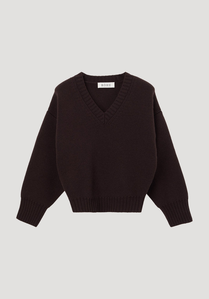 Sculptural compact V-neck dark brown sweater with long sleeves, ribbed cuffs, and hem, featuring a RÖHE label at the neckline. Expertly knitted from soft wool.