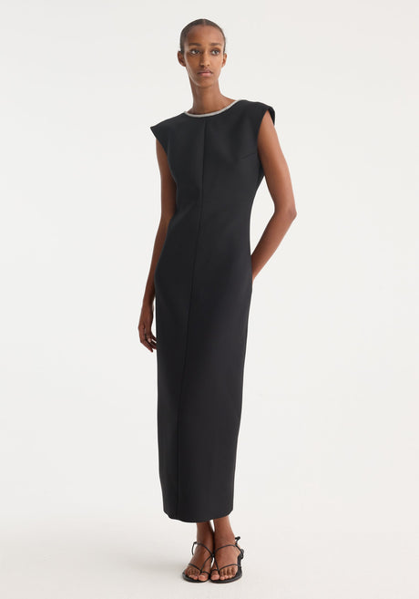 Open back appliqué dress | black: A woman in a form-fitting, sleeveless black maxi dress with a rhinestone neckline, open back, and caped shoulders, paired with black sandals.