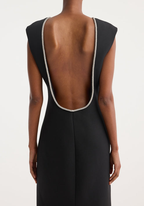 Open back appliqué dress | black: A woman in a form-fitting, sleeveless black maxi dress with a rhinestone neckline, open back, and caped shoulders, paired with black sandals.