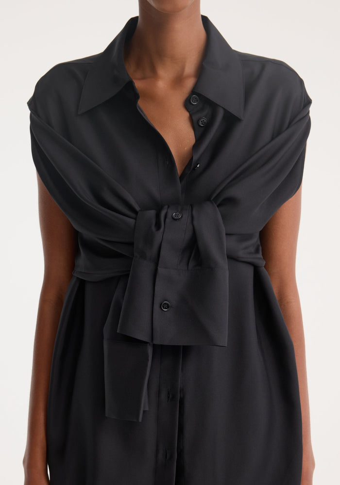 Silk gilet-dress in black, showcasing a deconstructed, layered look with a button-front and draped second shirt, highlighting a fluid silhouette with open armholes.