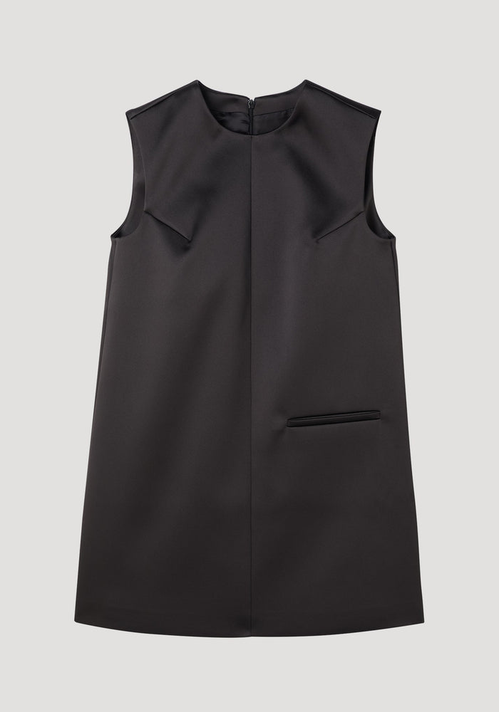 Sculptural cape dress in black, sleeveless A-line with a high neckline, single welt pocket, center-front seam, and dramatic box pleats for a tailored fit.