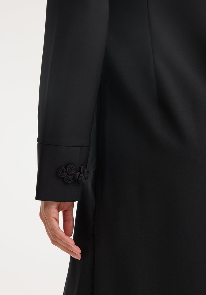 Mandarin dress | black: Close-up of a black sleeve with wide cuff and pankou closures, showcasing traditional craftsmanship in a modern wool-mohair blend.