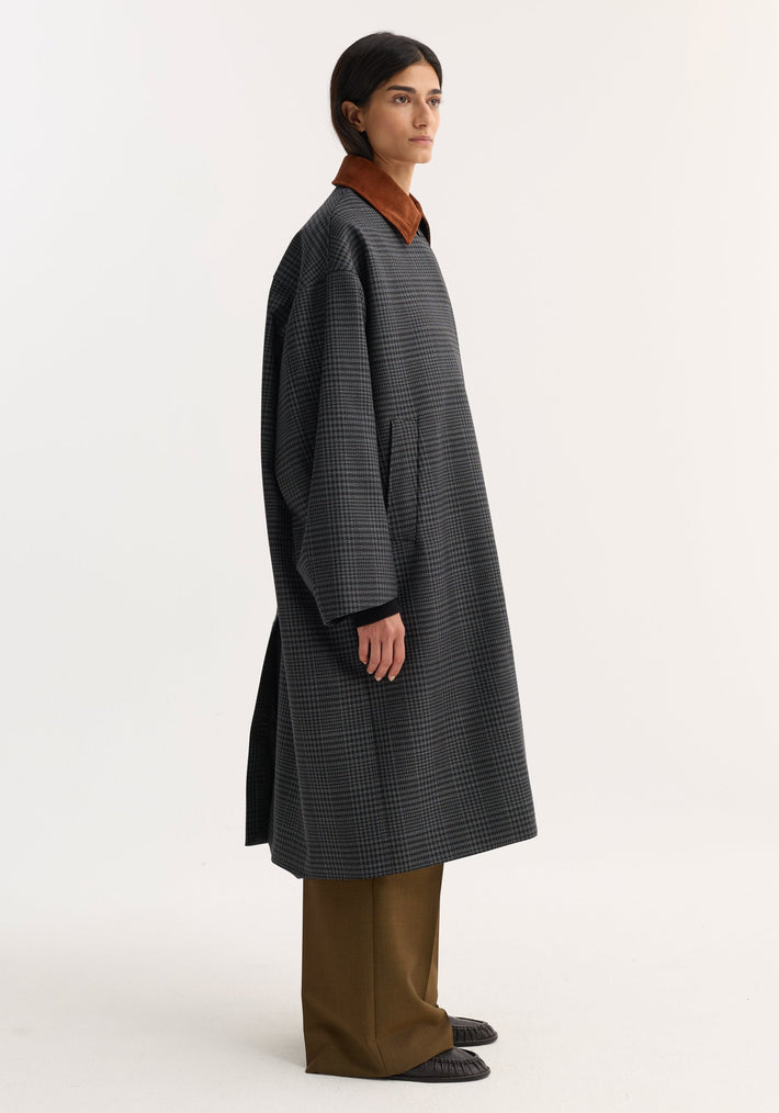 Model in an oversized Suede collar check coat | black / grey check, featuring a rust-brown suede collar, wide-leg trousers, and black loafers.