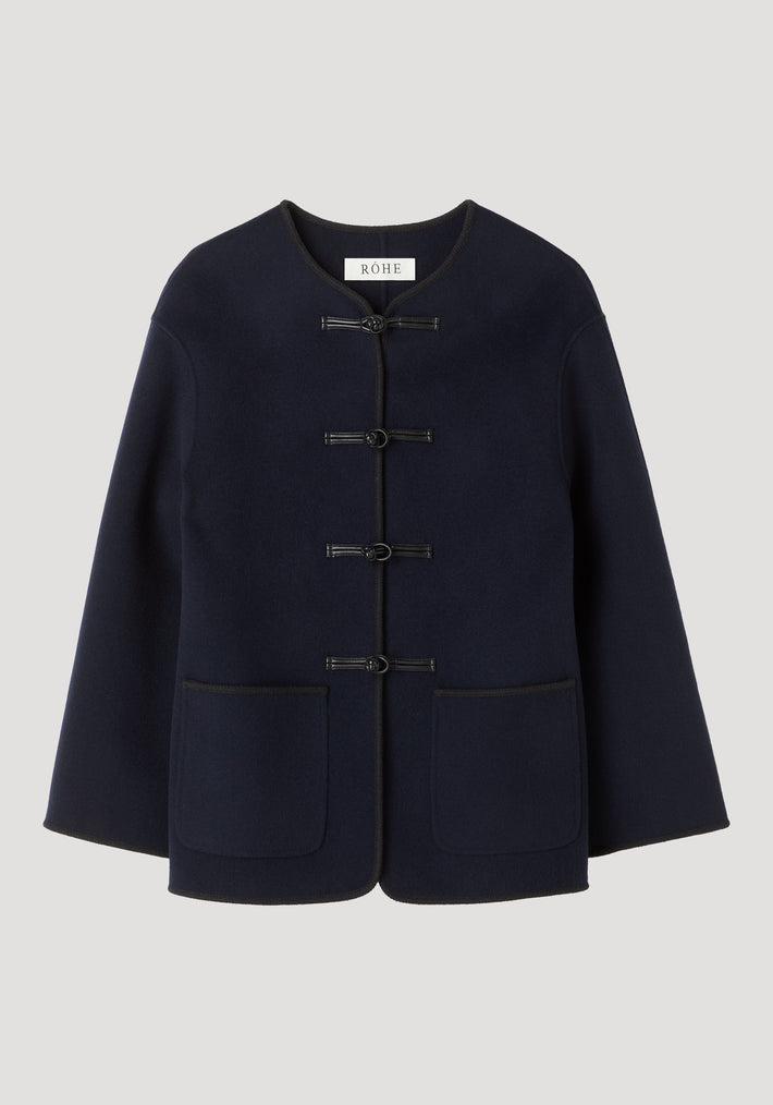 Double-faced wool pankou jacket in navy with frog-style toggles, embroidered edges, and patch pockets, showcasing traditional Chinese craftsmanship and a modern silhouette.