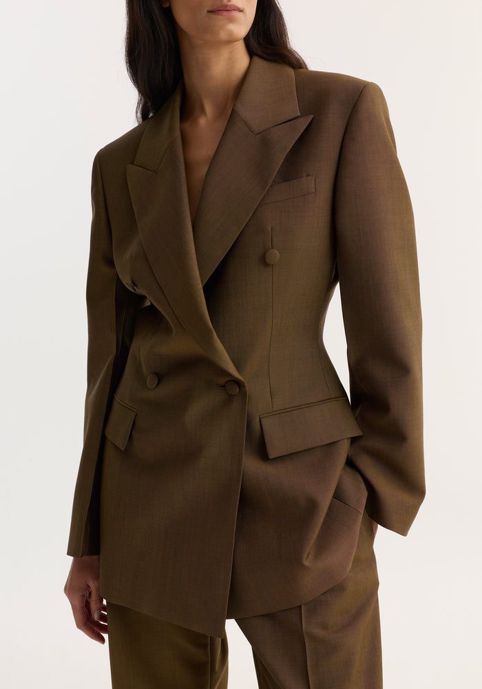 Hourglass blazer in golden brown featuring a double-breasted design, wide peaked lapels, covered buttons, and matching trousers, creating a structured, feminine silhouette.