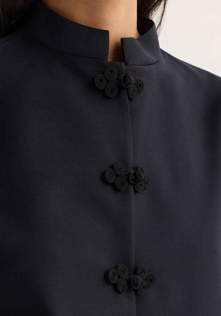 Close-up of Pankou closure jacket showcasing traditional frog closures and stand-up collar, highlighting artisanal craftsmanship in a virgin wool and mohair blend.