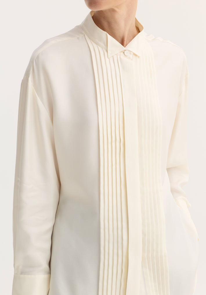 Shaped tuxedo silk shirt in cream, featuring a stand-up collar, pleated front, double cuffs, and hip pocket, crafted from pure silk for an elegant fit.