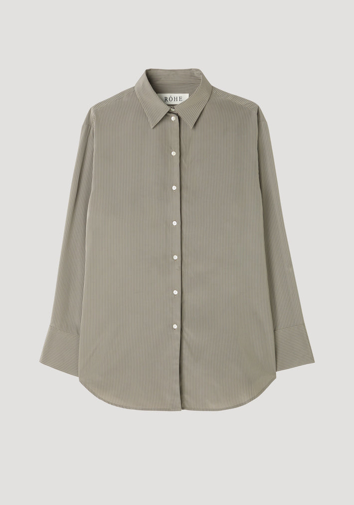 Relaxed shaped shirt featuring fine pin-stripes, button-down front, classic collar, elongated sleeve plackets, and curved hem, made from 100% viscose. Model wears size 36.