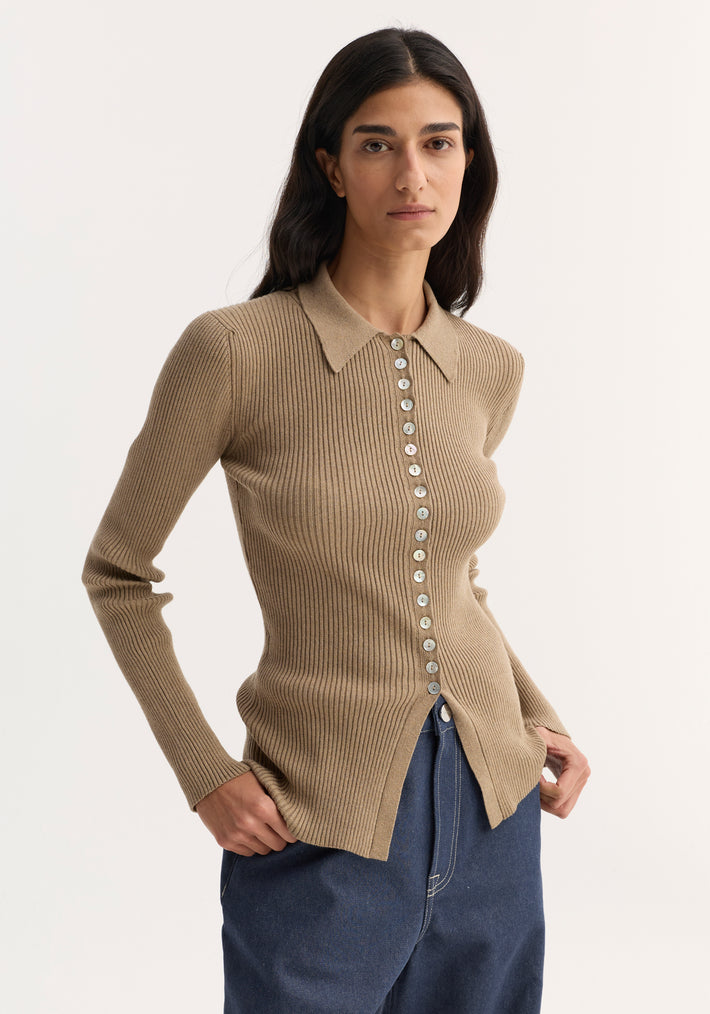 Woman wearing Elongated rib cardigan | taupe melange, fitted, rib-knit with collar, mother-of-pearl buttons, paired with dark-denim trousers, hands on hips.