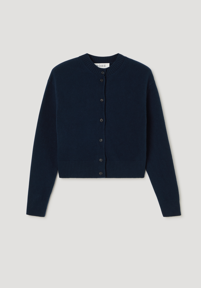 Short boiled cardigan in navy, featuring a crew neck, drop shoulders, button-down front, and ribbed cuffs. Made from wool for a soft, structured texture.