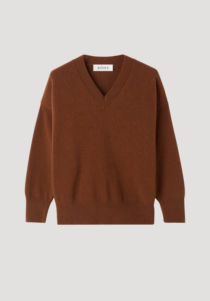V-neck knitted jumper in rich brown with long sleeves, ribbed cuffs, and hem. Features a relaxed fit, dropped shoulders, and RÓHE label inside the collar.