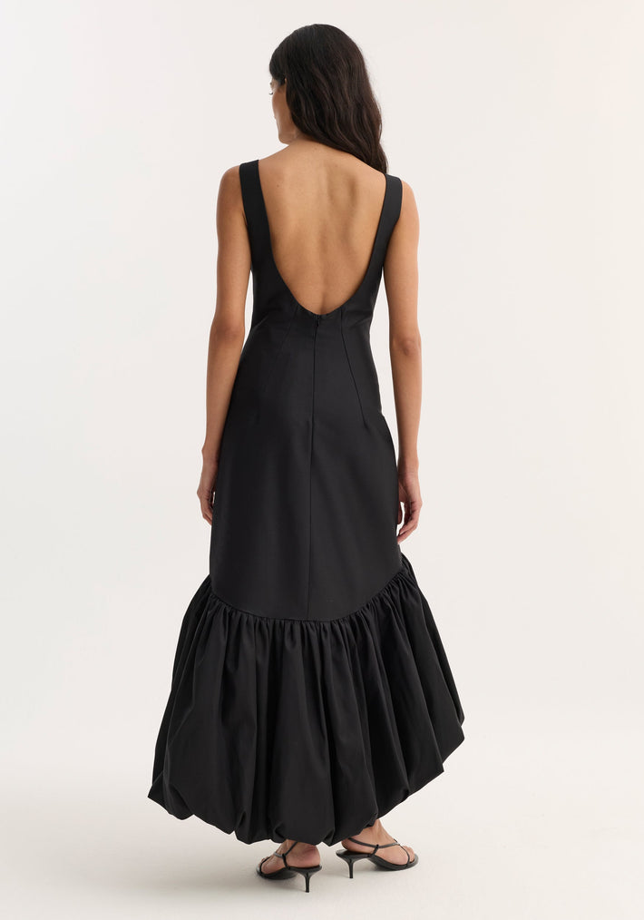 Voluminous dress | black, featuring a sleeveless design with a boat neckline, fitted bodice, deep scoop back, and a bubble hem, styled with strappy sandals.