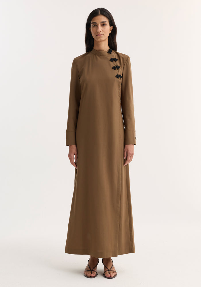Model wearing Pankou closure dress | mocha, featuring floor-length design, long sleeves, asymmetrical pankou buttons, and side split, paired with black strappy sandals.