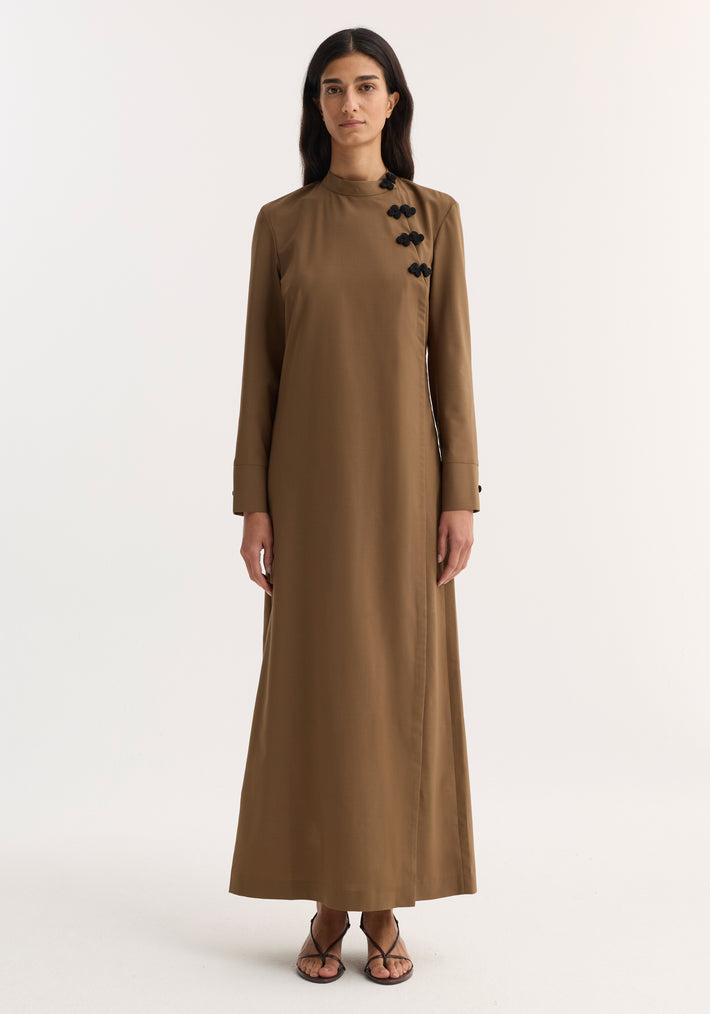 Model wearing Pankou closure dress | mocha, featuring floor-length design, long sleeves, asymmetrical pankou buttons, and side split, paired with black strappy sandals.