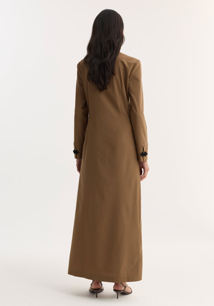 Back view of a person wearing a Pankou closure dress | mocha, featuring floor-length design, long sleeves, asymmetrical closures, and black strappy sandals.