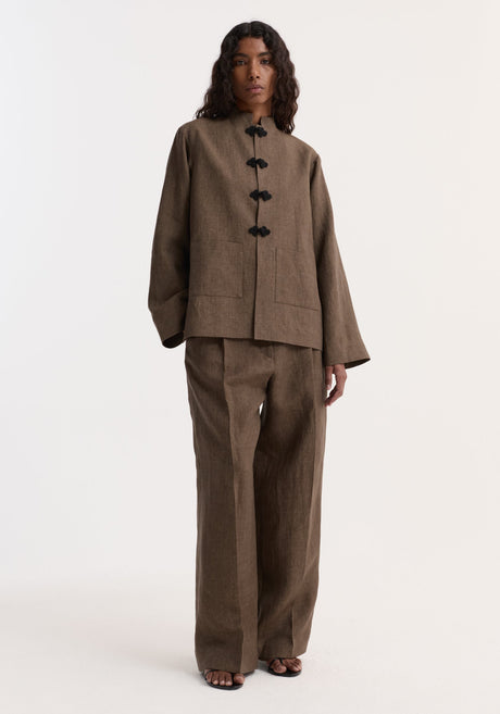 Person wearing Pankou closure linen jacket in brown melange with frog closures, patch pockets, matching wide-leg trousers, and black open-toe sandals.