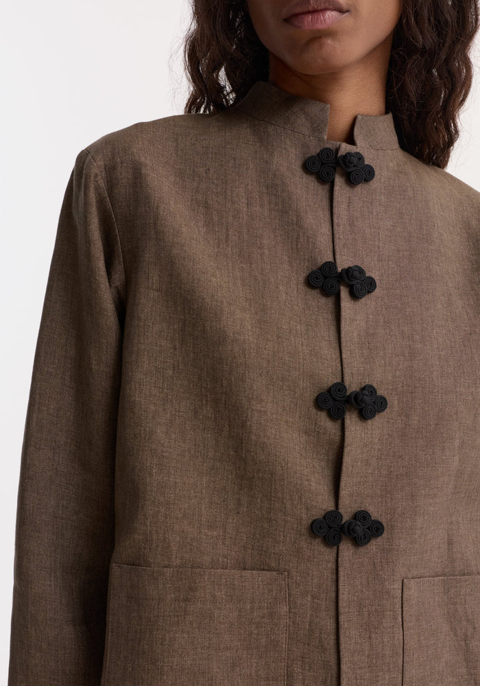 Pankou closure linen jacket with a Mandarin collar, featuring black decorative frog closures and hip-level patch pockets, crafted from breathable European flax linen.