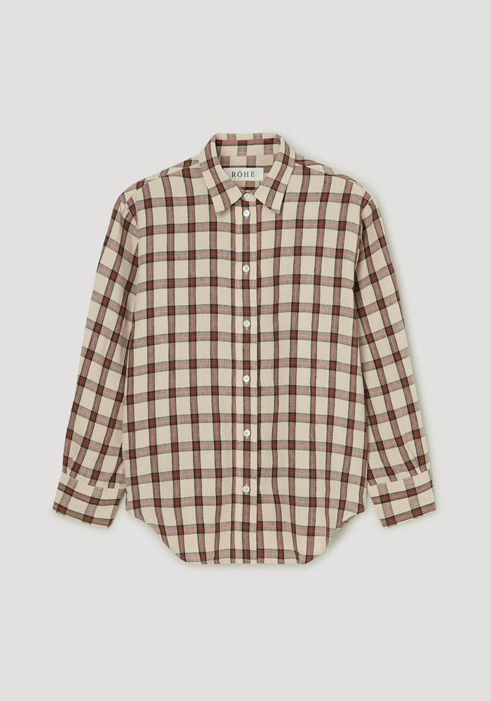 Oversized check shirt in beige plaid with red and black lines, featuring a relaxed fit, classic collar, white buttons, and a gently curved hem.