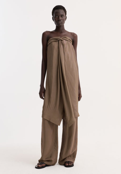 Model in Sarong top | brown mini check, featuring a knotted bust, front slit, and inner bustier, paired with matching wide-leg trousers and black sandals.