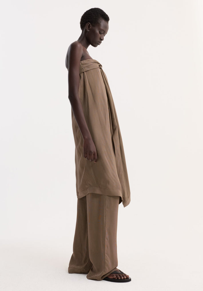 Model wearing Sarong top with front slit and knot detail, paired with wide-leg trousers and sandals, showcasing relaxed elegance and structured support.