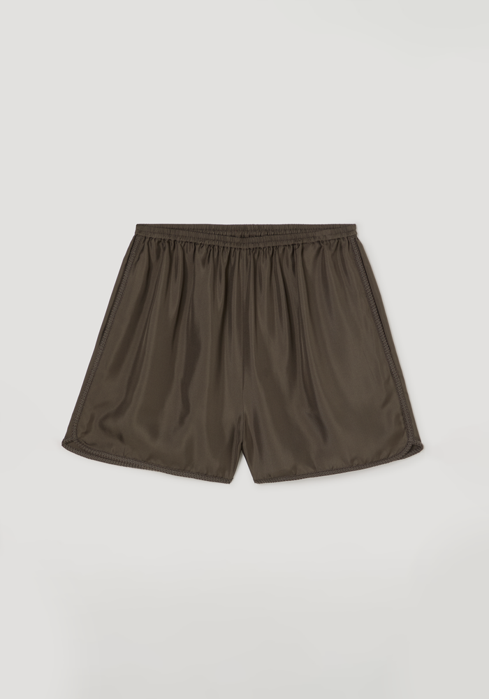 Taped silk shorts | earth featuring lightweight fluid design, elasticated waistband, and intricate embroidered hem detailing, laid flat to showcase pleating and tape accents.