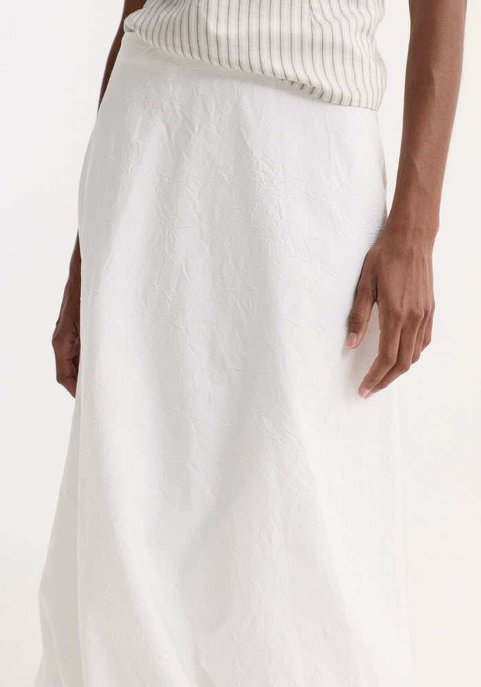 Twisted crushed cotton skirt in optic white, showcasing a mid-waist fit with a twist detail at the hem for added volume and movement.