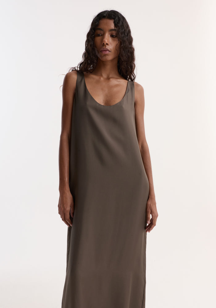 Woman wearing a Silk Scoop-Neck Dress | Earth, featuring a sleeveless, floor-length design with a deep scoop neckline, crafted from pure silk for a relaxed silhouette.