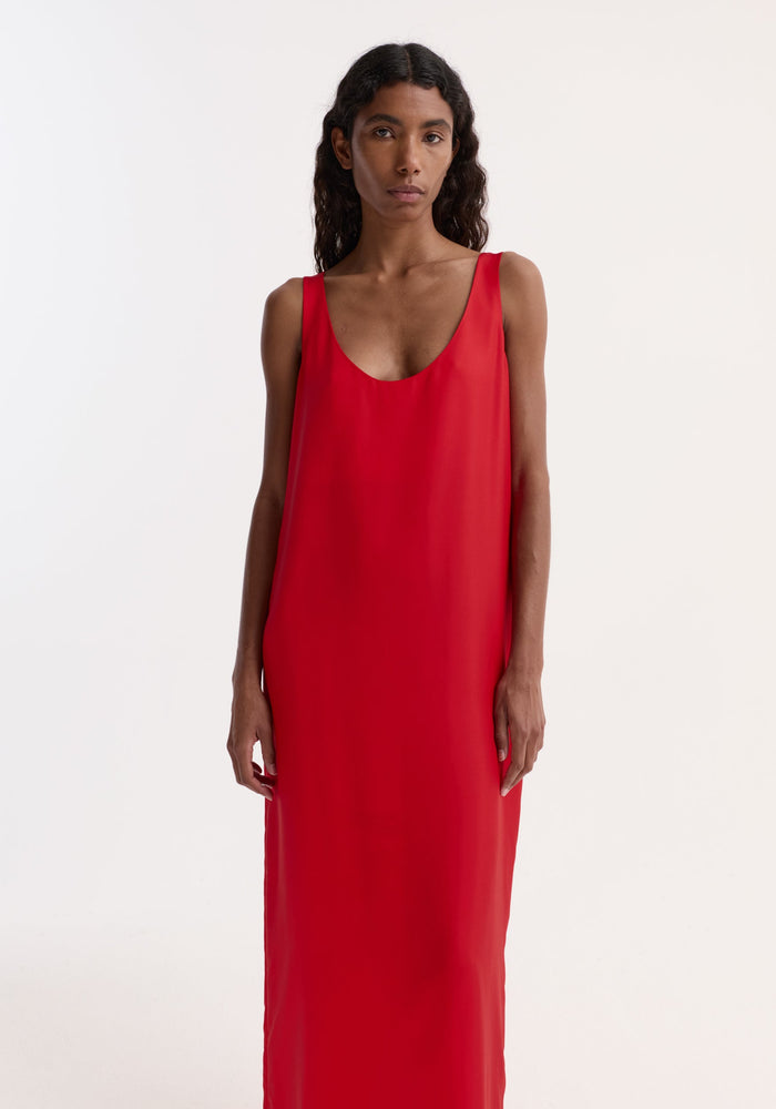Model wearing Silk scoop-neck dress | red, featuring a floor-length, sleeveless design with a deep scoop neckline, crafted from 100% silk for an elegant silhouette.
