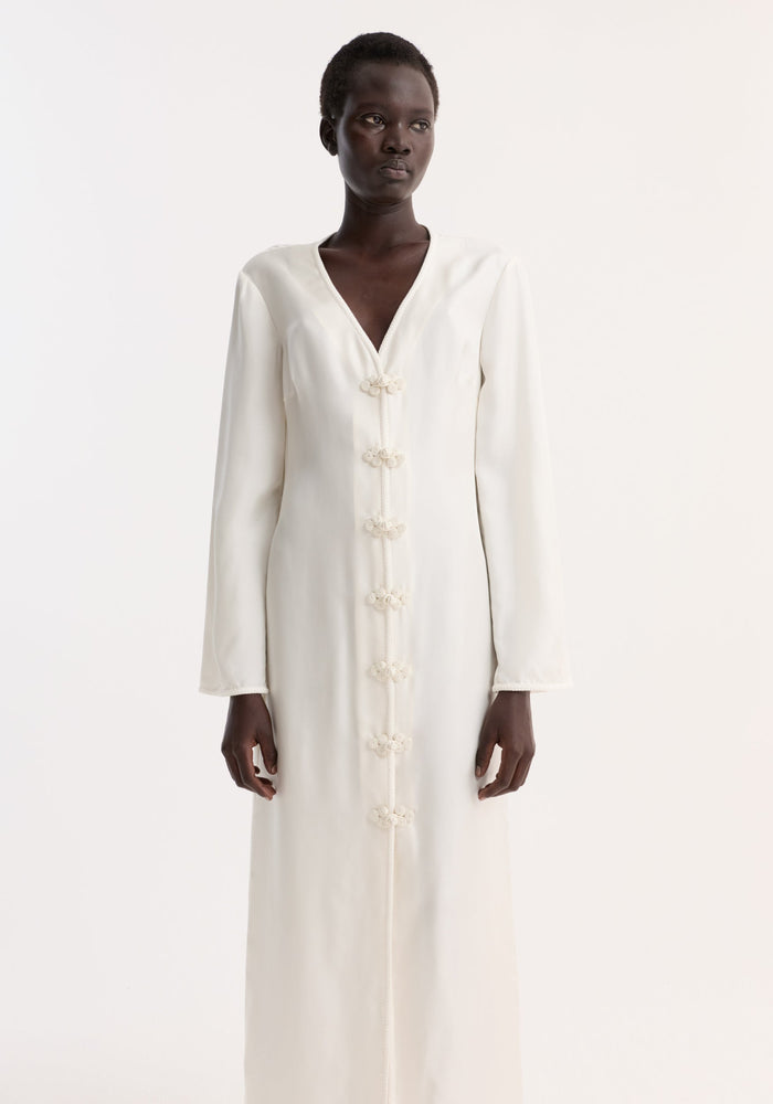 Pankou closure silk dress | cream: A slender woman models a full-length, pure silk dress with pankou closures, V-neckline, and elegant high front split.