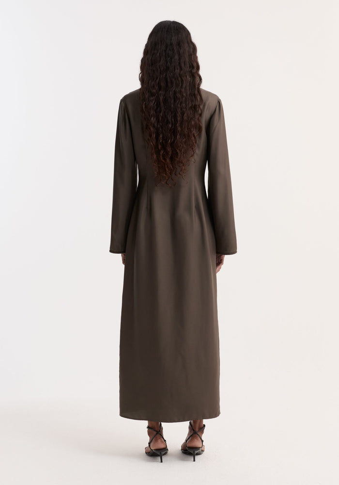 Pankou closure silk dress | earth: Person in full-length, long-sleeved silk dress with pankou closures, V-neckline, high front split, wearing black sandals, hair in loose waves.