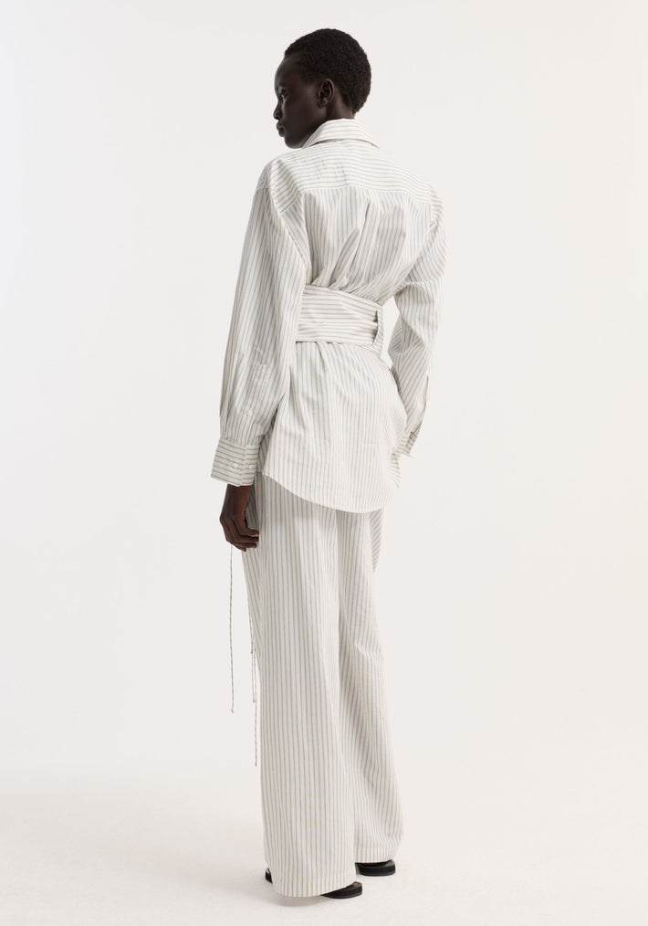 Model wearing Silk stripe belted shirt with wide sleeves, button-down design, and matching trousers. Shirt features a removable belt for adjustable fit.