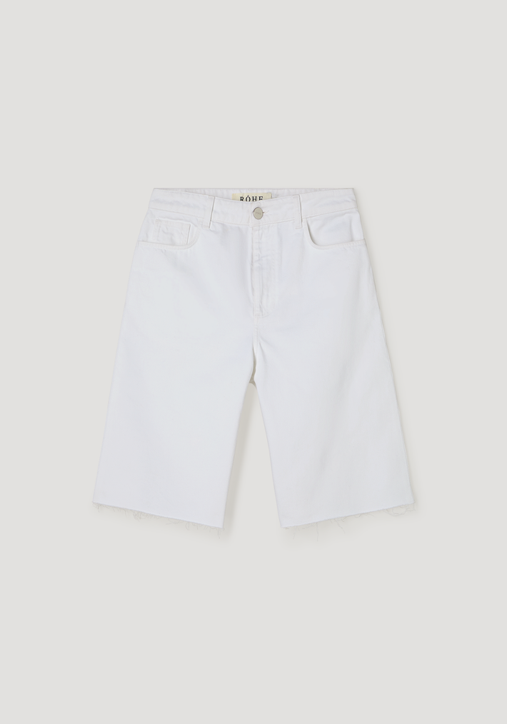 Baggy fit denim shorts in optic white, featuring knee-length Bermuda style, raw frayed hem, classic five-pocket design, and a relaxed, casual look.