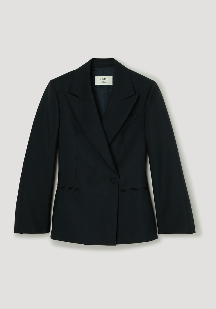 Hourglass shaped blazer with peaked lapels, single button closure, structured shoulders, and slit pockets; features a sculptural, tailored silhouette by RÓHE.