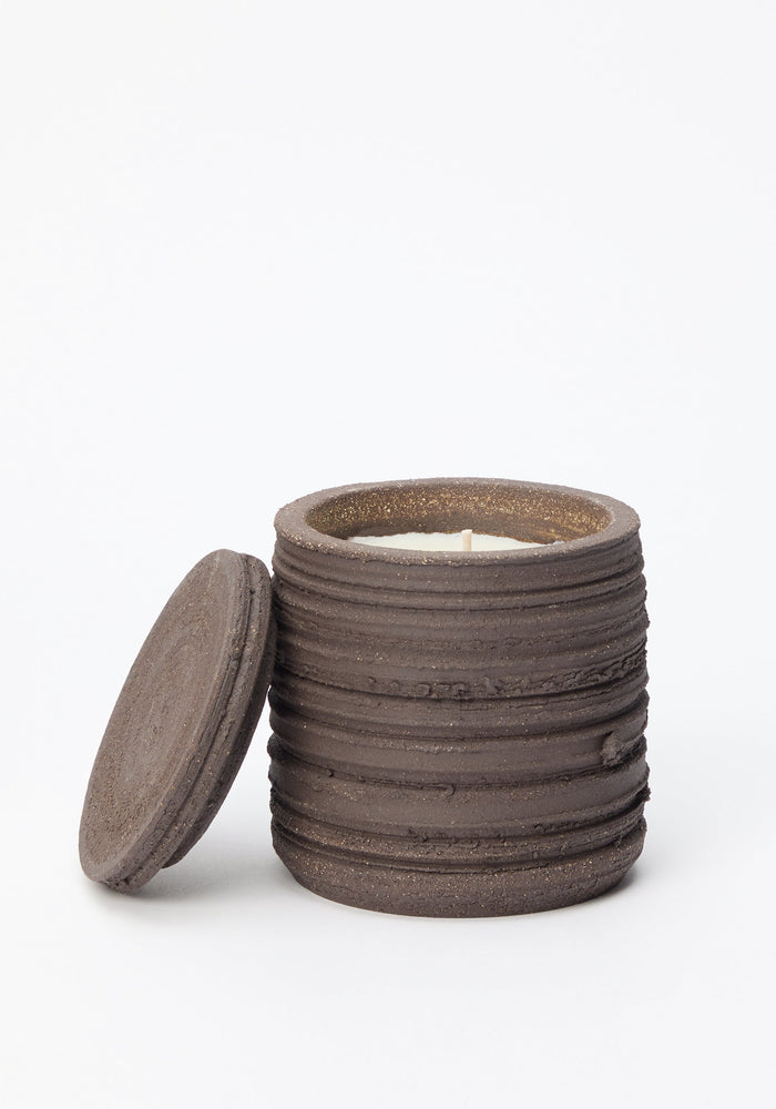 Handcrafted Diplomatico Scented Candle in a ribbed, dark-brown ceramic jar with lid. Features woody-aromatic fragrance; doubles as sage-burning coaster.