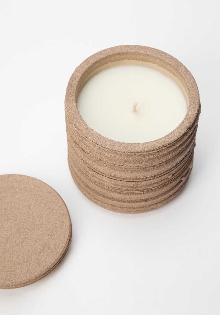 Diplomatico Scented Candle in a round, stacked-cork container with a matching lid, featuring a handmade ceramic vessel by Alex Gabriels.