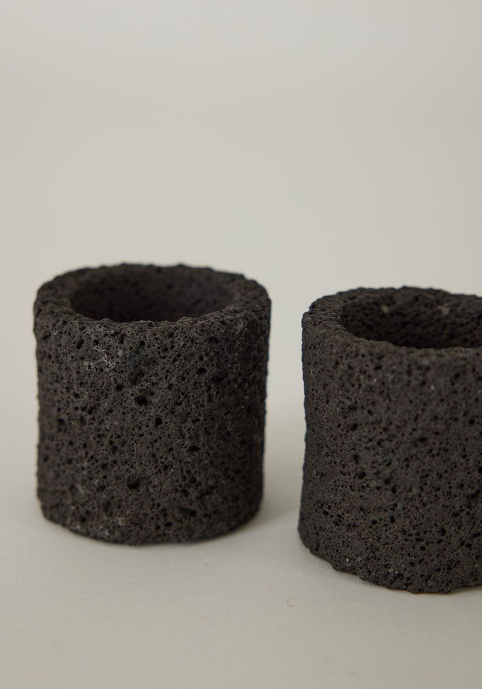Egg Cups handcrafted from porous lava stone, featuring two small, hollow cylinders. Unique and artisanal design by Dutch artist Louis Crombag.