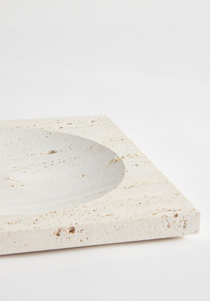 Medium tray | travertine: A square stone tray with a circular indent, crafted from Italian travertine by Louis Crombag, showcasing natural, unique textures.