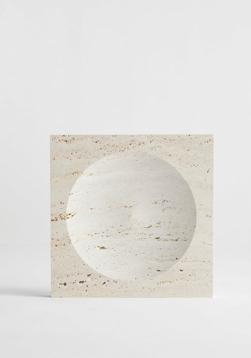 Medium tray | travertine: A square travertine block with a round, shallow indent, handcrafted by Louis Crombag, showcasing its natural porous texture and unique design.