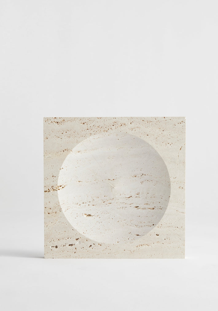 Medium tray | travertine: A square travertine block with a round, shallow indent, handcrafted by Louis Crombag, showcasing its natural porous texture and unique design.