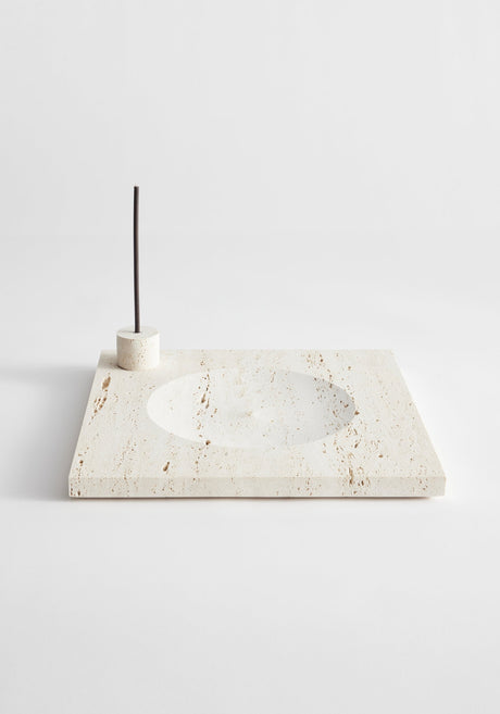 Large tray | travertine: A cream travertine slab with a circular recess and cylindrical holder for incense or candles, handcrafted by Louis Crombag in the Netherlands.