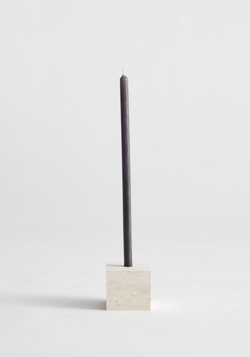Two-way cube candleholder in travertine, featuring a dark gray taper candle in a beige stone holder, handcrafted by Dutch artist Louis Crombag.