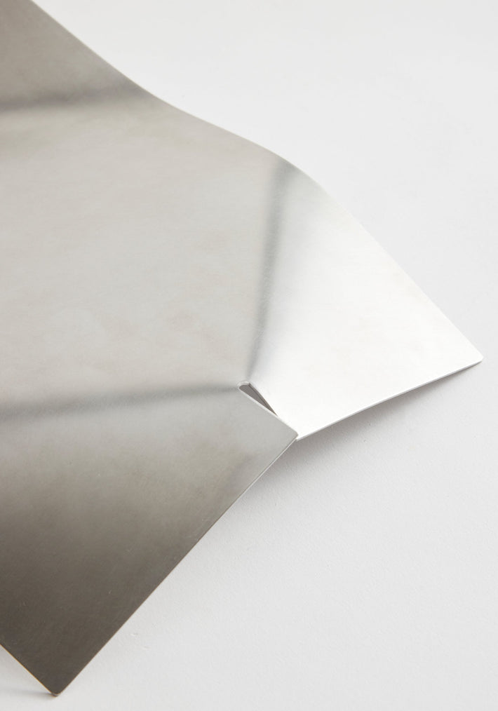 Stainless steel bowl, minimal bended shape, handcrafted from a flat metal sheet with a small corner fold, designed by Paul Coenen.